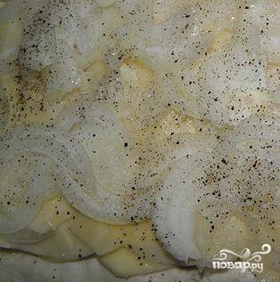Репчатый лук очистите и также нарежьте такими же тонкими кольцами (или полукольцами). Делать это удобнее при помощи специальной насадки в терке. Выложите слой лука поверх картофеля. Присыпьте солью и перцем. Сделайте несколько таких картофельно-луковых слоев. 