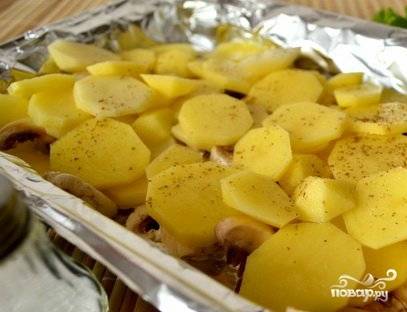 Картофель очищаем и режем кружочками. Кладем поверх грибов, добавляем специи и соль. Второй слой уложен.