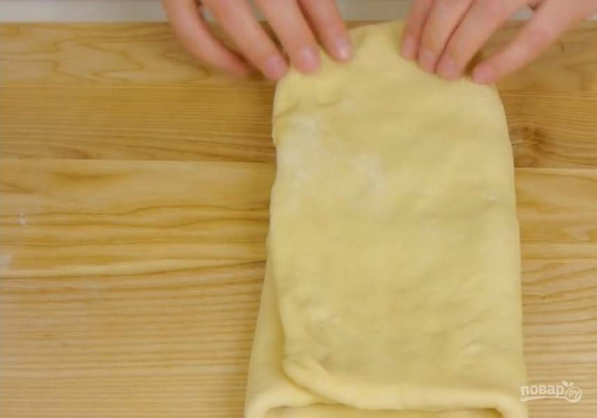 4. Тесто растяните в прямоугольник на посыпанной мукой доске. Сложите тесто втрое, затем снова втрое. Накройте миской и оставьте на 30 минут. Снова так же сложите тесто, накройте миской и оставьте на 30 минут.