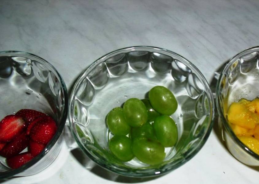 В формочки для десерта выложите кусочки фруктов и ягоды. 