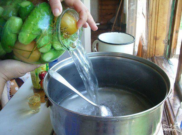 Далее слить воду из огурцов и помидоров в кастрюлю.