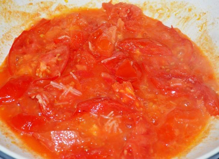 Последними немного протушите на сковороде колечки помидор с измельченным чесноком. 