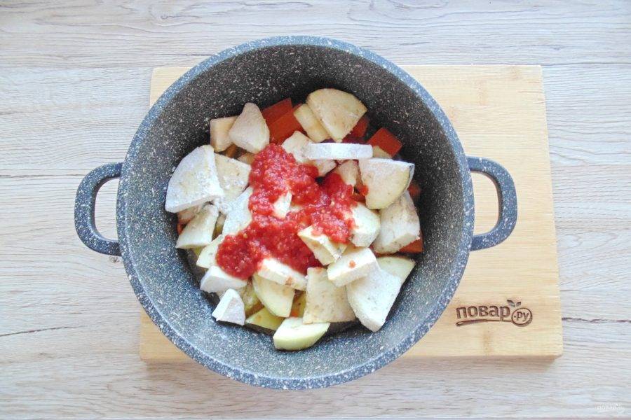 Помидор измельчите любым способом. Можно взять готовый томатный морс или томатную пасту. Добавьте в кастрюлю с овощами. Налейте приблизительно 100-150 мл. воды. Посолите и поперчите по вкусу. Накройте кастрюлю крышкой и тушите овощи на небольшом огне почти до готовности.