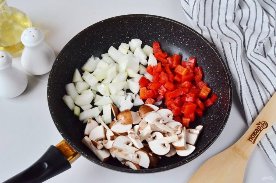 Очистите лук, нарежьте овощи кубиками, а грибы — слайсами. Обжарьте все овощи сразу на растительном масле до мягкости.