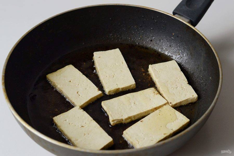 Разогрейте сковороду на среднем огне. Обжарьте тофу в масле по 2 минуты с каждой стороны. 
