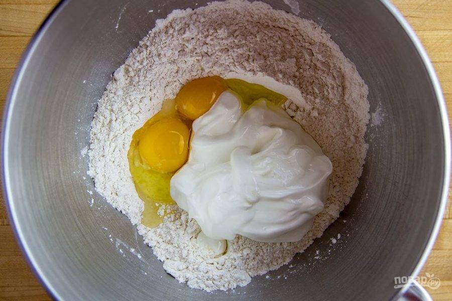 4.	В миску просейте муку, добавьте целое яйцо и куриный желток, а также сметану, разрыхлитель, соль.