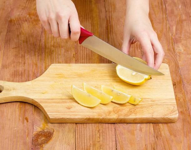 12. Нарежьте дольками или кружочками лимоны. Оставьте несколько для подачи, остальные отправьте в кастрюлю. 