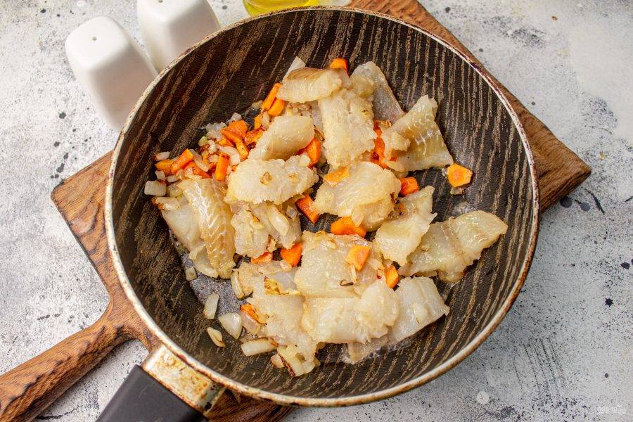 В сковороде на растительном масле обжарьте до мягкости лук и морковь, добавьте кусочки рыбы и готовьте еще пару минут вместе. 