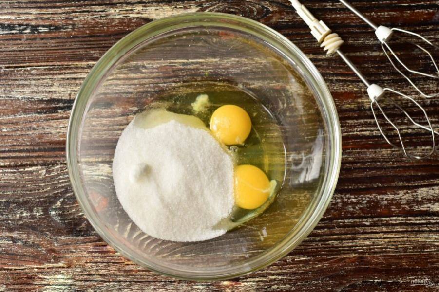В миску вбейте куриные яйца. Добавьте к ним сахар и соль.