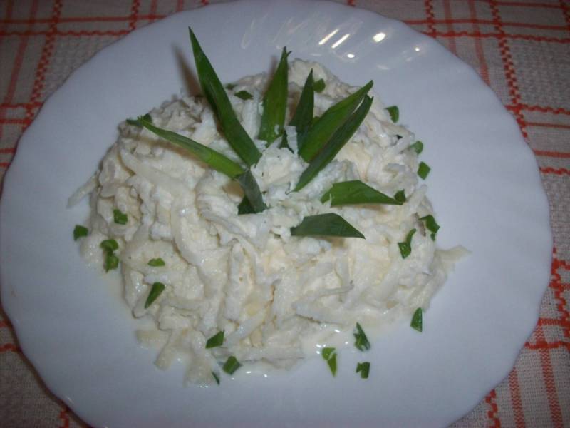 5. Выкладываем салат из редьки со сметаной на блюдо, украшаем зеленым луком.