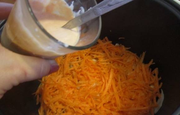 Теперь выкладываем тертую морковь, равномерно распределив ее по поверхности. Готовим 7-8 минут.
