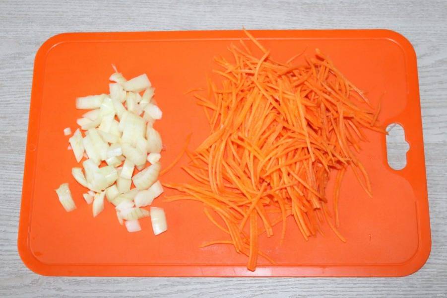 Лук нарежьте кубиками, морковь натрите на тёрке для корейской моркови.