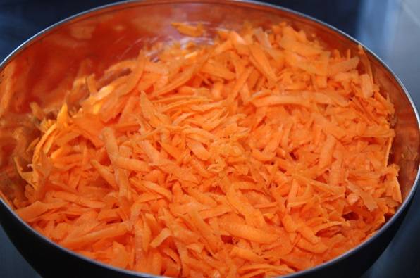 Почистите и натрите на крупной терке морковь.