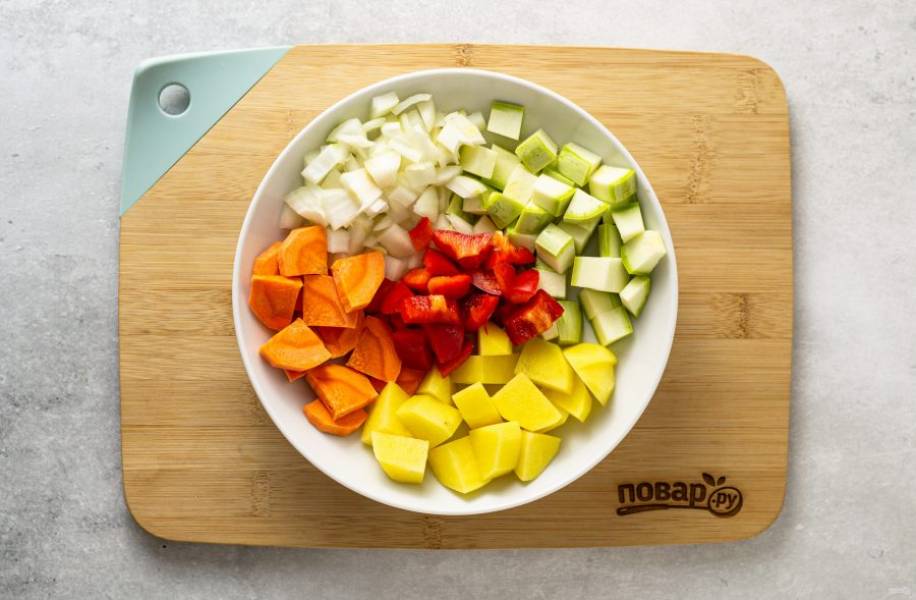 Кабачок, лук репчатый и картофель нарежьте кубиками, морковь ломтиками среднего размера. Сладкий перец очистите от семян и порубите квадратиками.