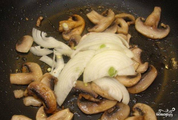 Как грибы подрумянятся, добавьте к ним лук. Обжарьте ингредиенты вместе на максимальном огне в течение 3-х минут.