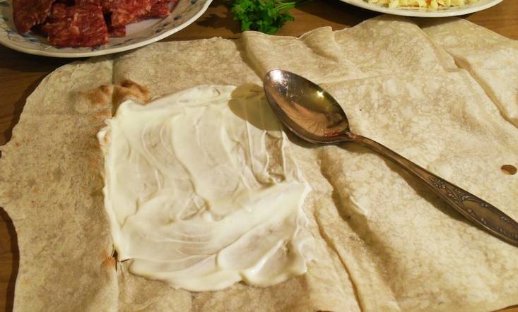 1. Лаваш расстилаем и равномерно смазываем сметаной и сливочным сыром. 