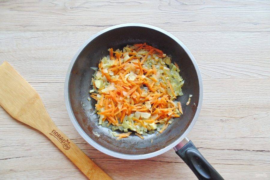 Морковь и лук очистите, помойте. Лук мелко нарежьте, а морковь натрите на терке. Выложите в сковороду с подсолнечным маслом. Тушите 7-8 минут, периодически перемешивая.