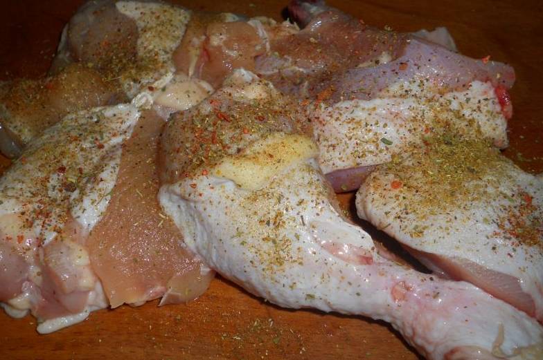 Кусочки курицы необходимо посолить и посыпать специями  (в том числе и хмели-сунели).