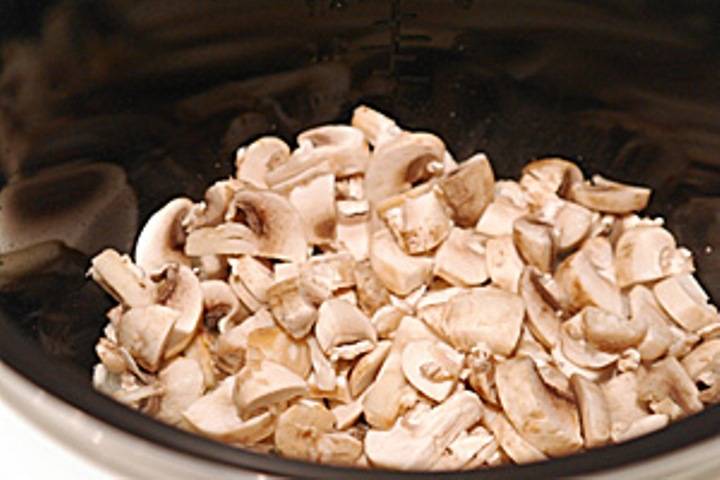 Затем добавьте в чашу порезанные грибы и также обжарьте. 