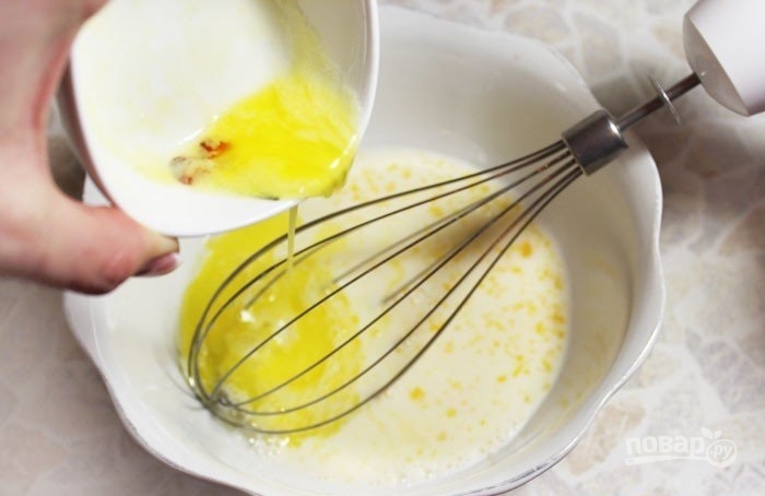 4. Молоко влейте в миску, добавьте яйцо, растопленное и охлажденное сливочное масло, соль и взбейте.