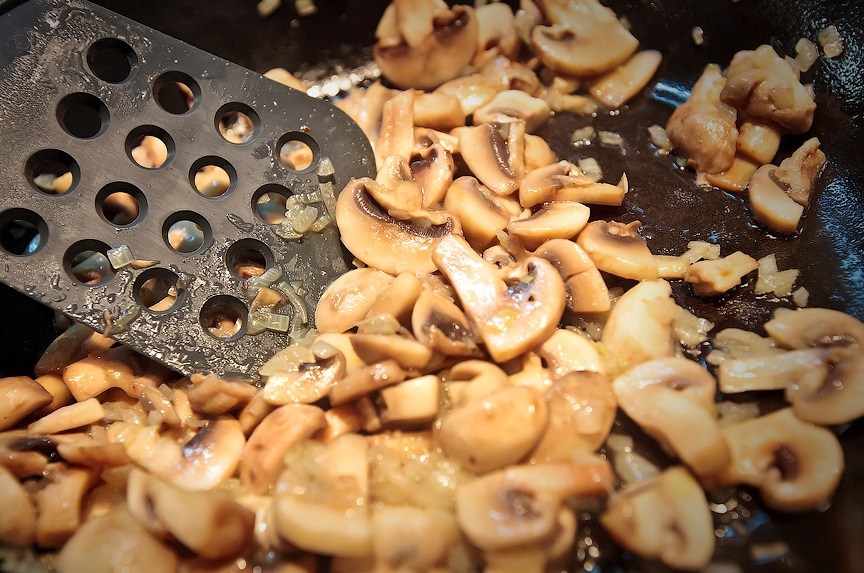 Разогреваем на сковороде растительное масло и обжариваем на нем лук до золотистого цвета, затем добавляем к луку нарезанные грибы. Жарим все, помешивая, минут 7-10, затем снимаем сковороду с огня, солим и перчим грибы по вкусу.